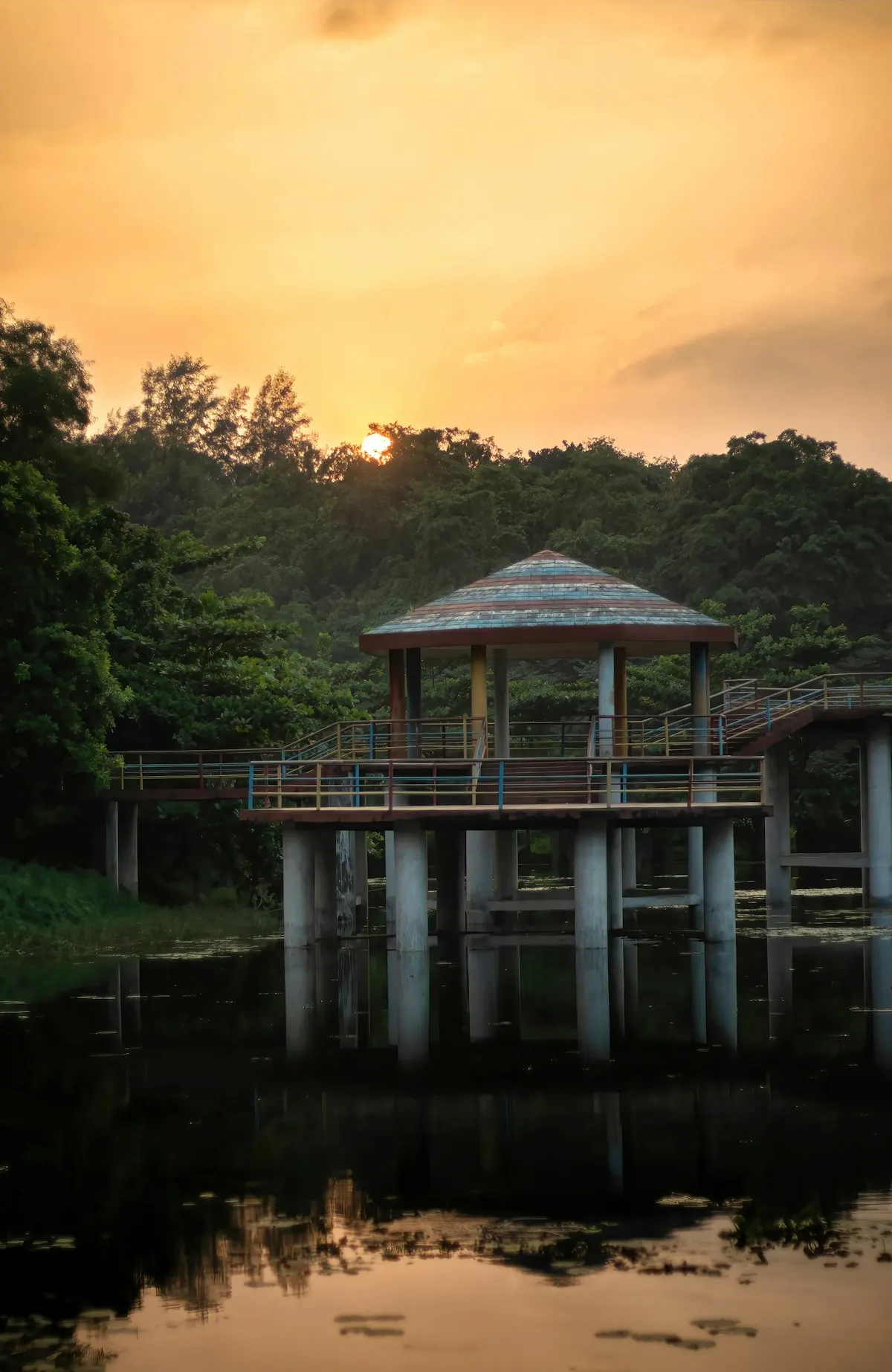 Garden pavilion beside a pond at dusk